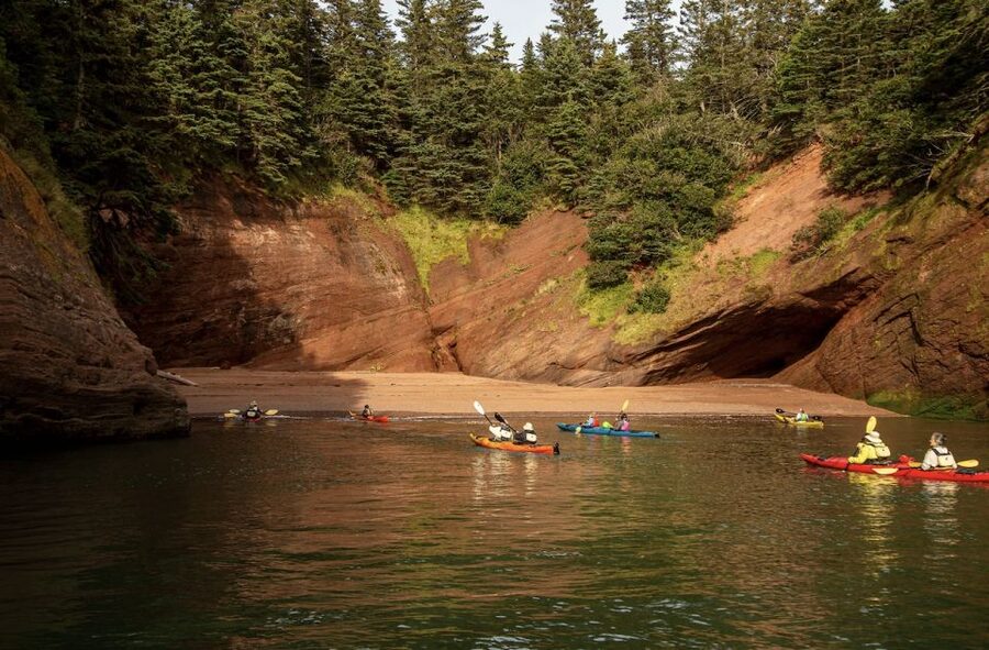 Saint John: Guided Kayaking Tour of St. Martins Sea Caves - Entering the sea caves beneath the red cliffs